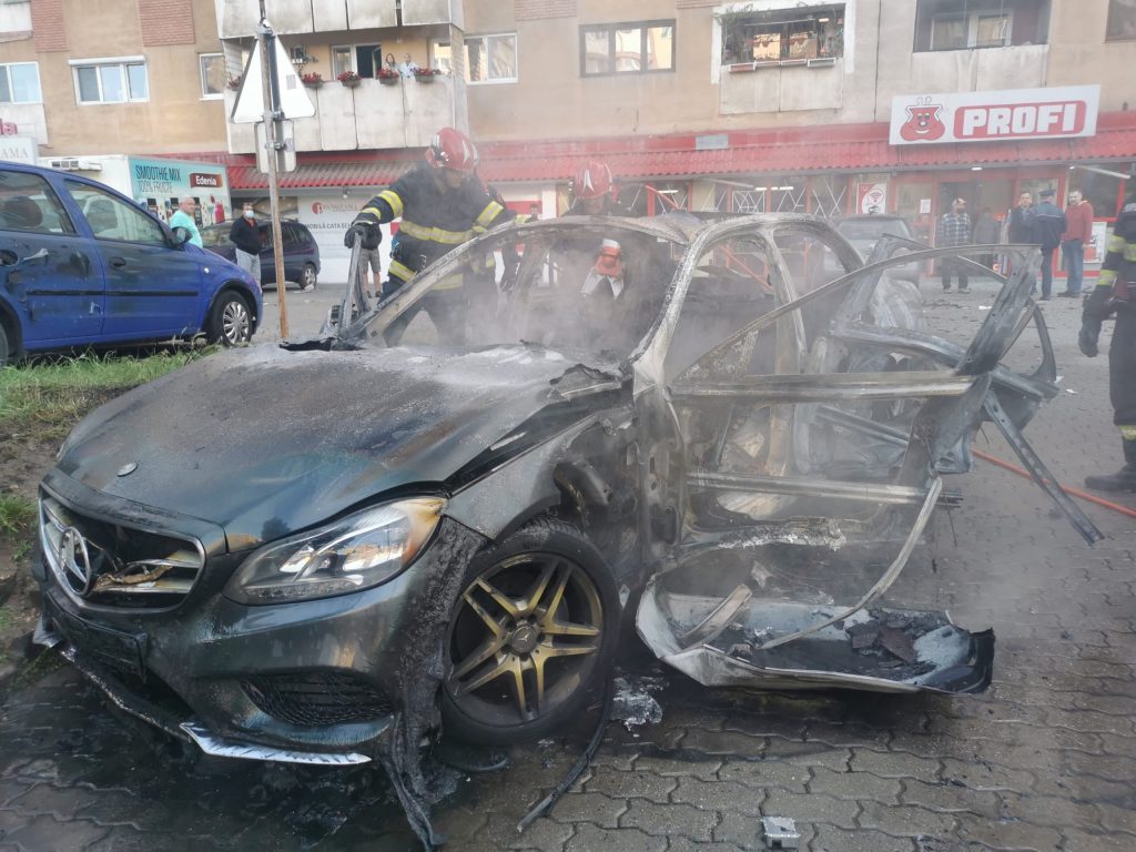 Arad: Mașină în flăcări în parcarea unui supermarket. În interior un afacerist mort