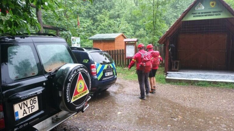 FOTO. Intervenție dificilă a salvamontiștilor. Trei adulţi şi doi copii, în pericol din cauza unei bucăți de drum surpate de ploaie